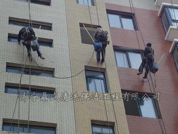 在樓頂架設吊籃將工人運送到指定位置進行施工操作